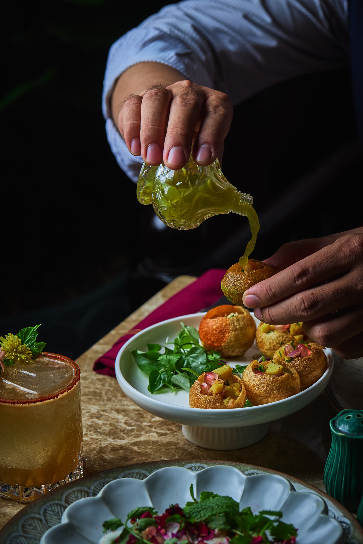 Pani puri being finished at the table