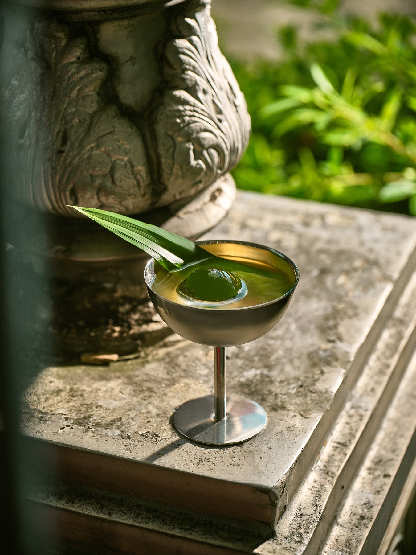 Cocktail on a stone ledge with greenery