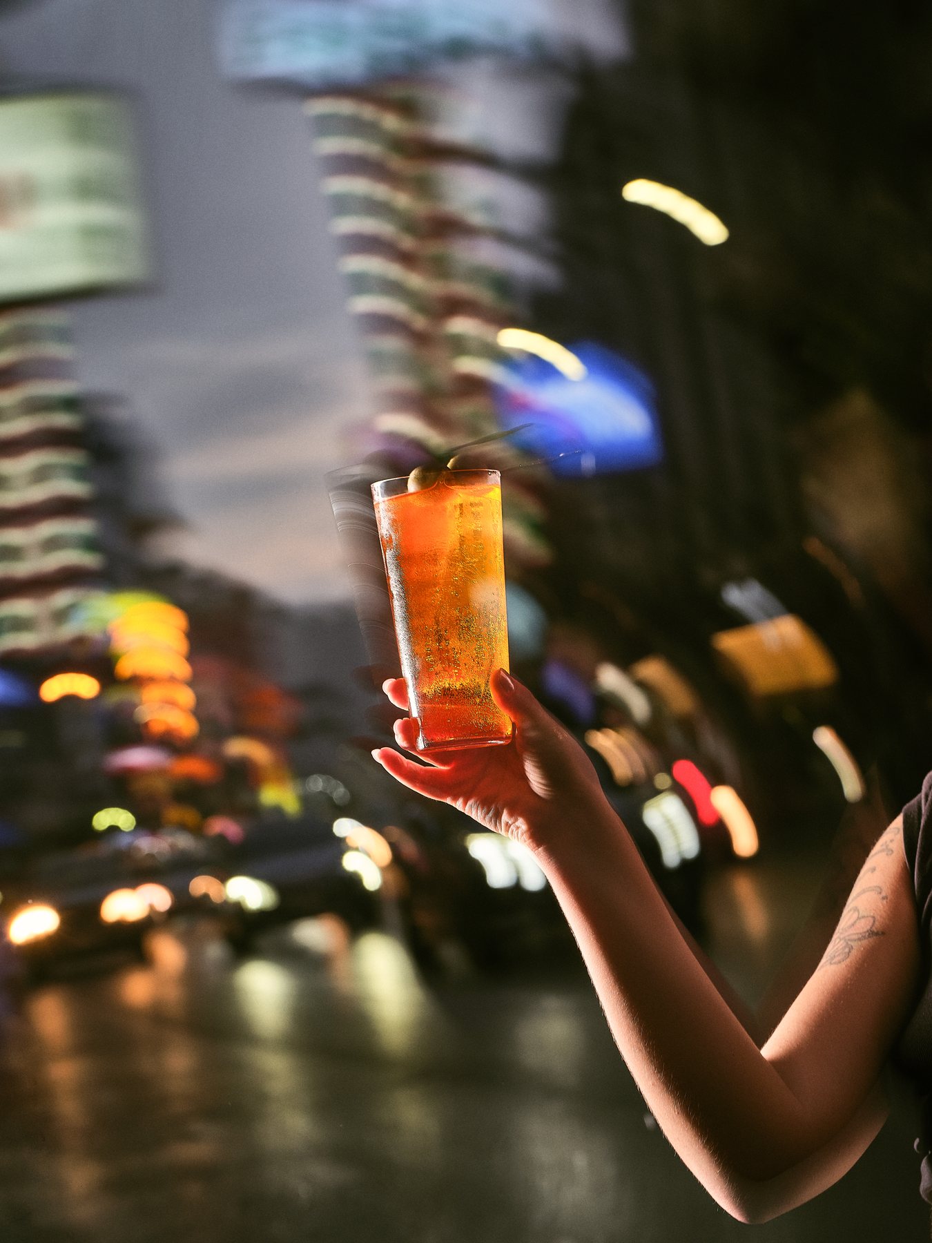Cocktail held up against Bangkok street lights