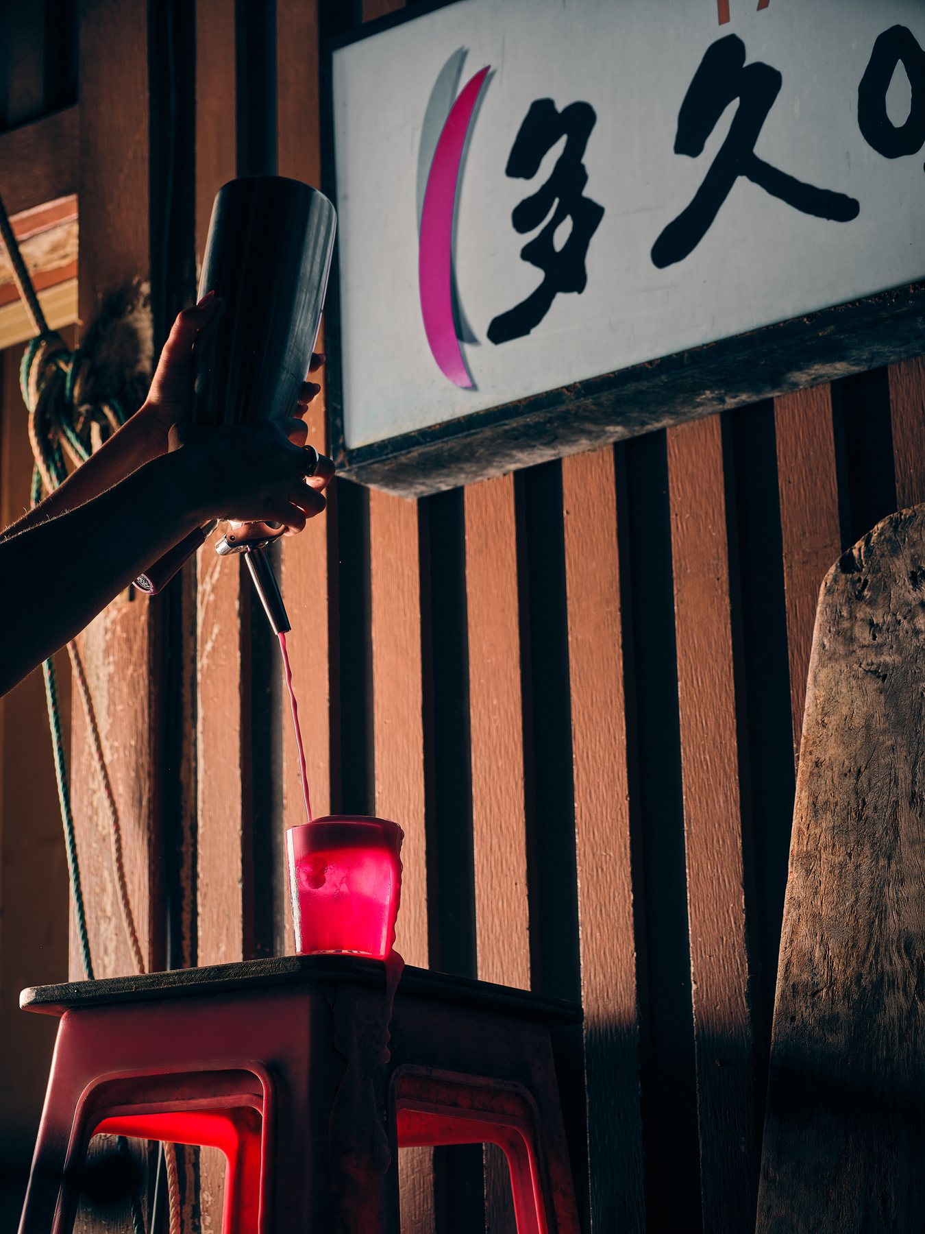 Cocktail on a red stool under Japanese signage